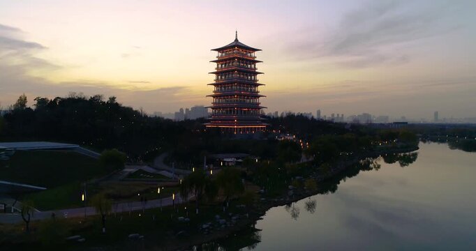 Illuminated Traditional Chinese Pagoda Tower Reflecting in Lake at Dusk with City Skyline in Xi an, China