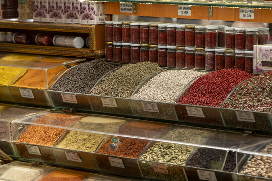 View of a vibrant display of various spices and herbs in glass containers and open bins at a market stall in Istanbul, Istanbul, Turkiye.