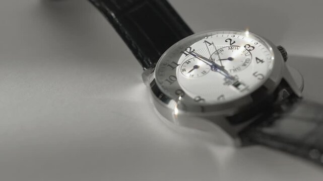 Timelapse Of Moving Clock Hands On Classic Wristwatch In Sunlight On White Background. Time Goes By Watch Time Lapse. Copy Space. Movement of clock hands on a classic wristwatch. The close-up view