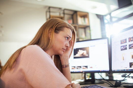 Stressed woman working at computer in modern office