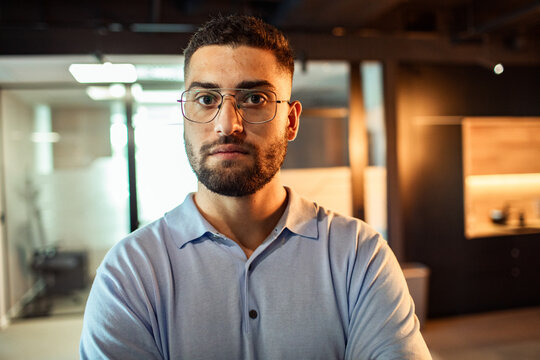 Confident young man with glasses in modern office