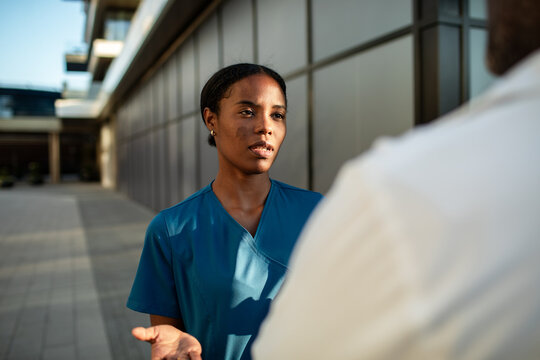 Nurse talking with colleague outside hospital building