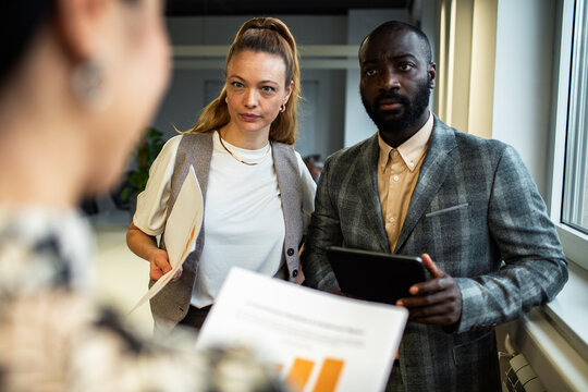 Coworkers listening to a presentation in modern office
