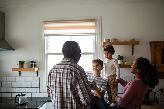Multigenerational family talking in bright kitchen at home