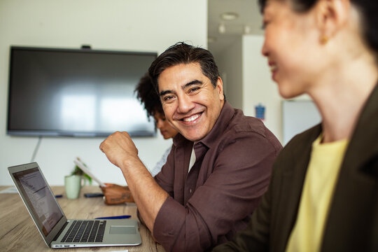 Smiling businessman collaborating with colleagues in modern office