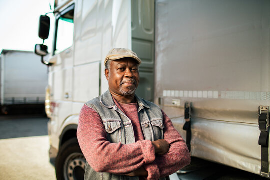 Portrait of confident truck driver at logistics yard