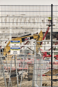 Taulov, Denmark - 28 August 2026: View of the Google Data Center construction site with a yellow excavator visible behind a metal security fence and a no trespassing sign.