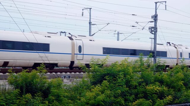 High-speed train passing through a rural landscape on an elevated railway track