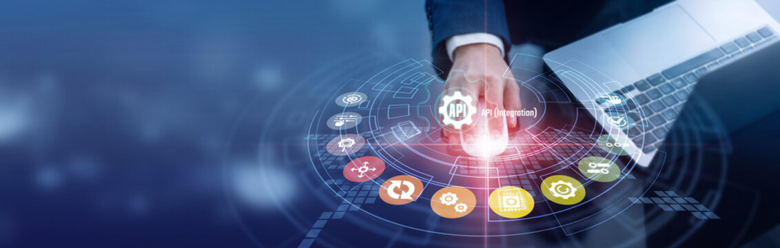 Software developer working on laptop and mouse analyzes APIs, data exchange, and system links. Professional working on laptop manages API Integration systems, data, and operations efficiently.