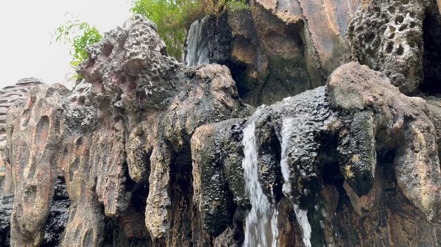 Natural limestone rock formation with small trickling waterfall