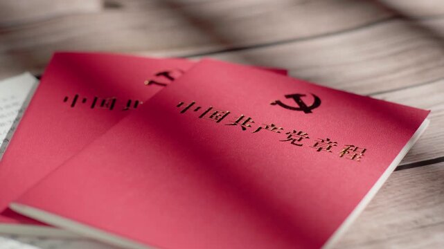 Red Chinese Communist Party Constitution Booklets on Wooden Table in China