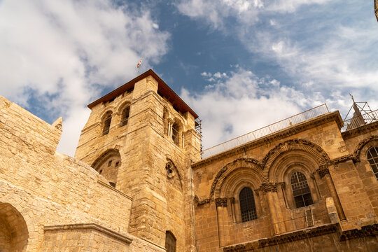 Jerusalem, Israel - 19 May 2023: View of the historic Church of the Holy Sepulchre in the Christian Quarter, featuring its ancient stone bell tower and arched windows.