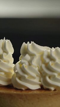 Vertical video: Squeezing pastry bag, hand decorating brulee tart rim on plating table