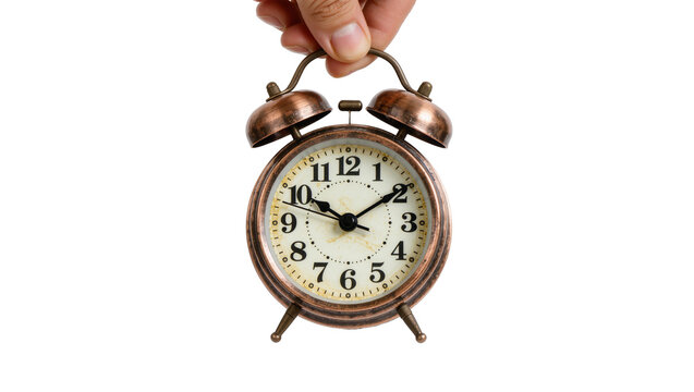 Hand holding vintage bronze alarm clock with two bells, isolated on transparent background