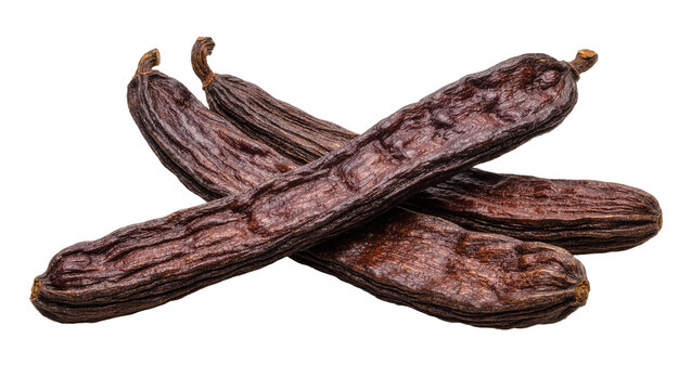Three dried dark brown carob pods with textured surface, isolated on transparent background