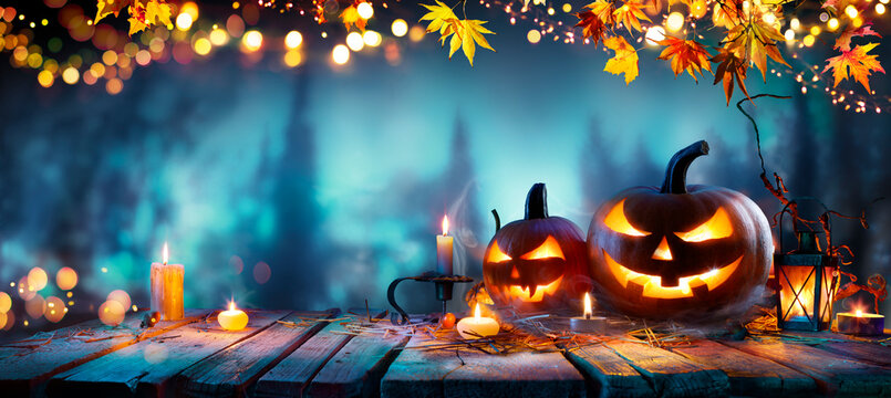 Halloween Pumpkins - Jack O&rsquo; Lantern On Wooden Table In Blue Defocused Forest At Night With Abstract Bokeh Lights