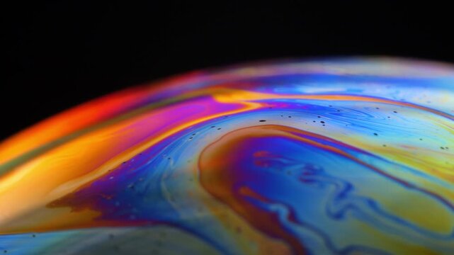 Rainbow multilayer film. Spherical abstraction of iridescent blue, yellow and red colors with soft focus. The natural environment.