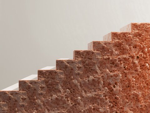 A close-up view of a staircase made from porous, rough, reddish-brown stone rising against a plain, light-colored neutral background