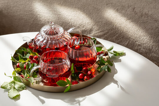Refreshing Rosehip Tea Served in Elegant Glassware on a Round Tray