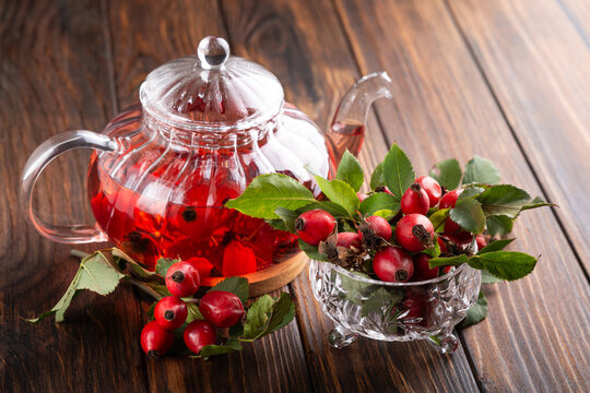 Warm Rosehip Tea Brewed in a Clear Glass Teapot with Fresh Berries