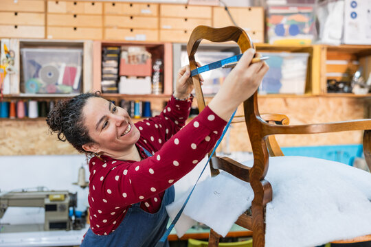 Woman measuring chair for upholstery restoration process