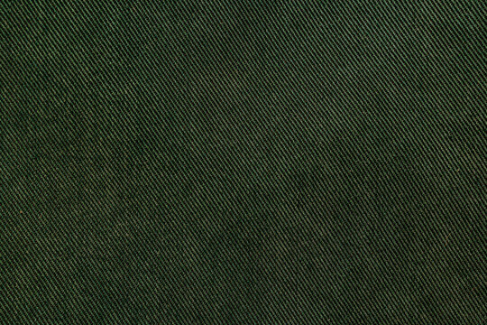 Dark green twill fabric texture background close up