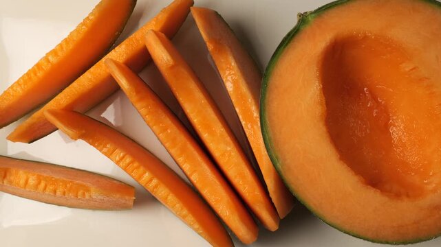Fresh ripe cantaloupe melon slices on white background