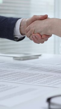 Business executives shaking hands, sealing an agreement after successful negotiations in a bright office, symbolizing partnership, collaboration, and a mutually beneficial deal signing