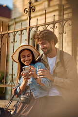 Happy tourist couple using mobile phone during trip together.