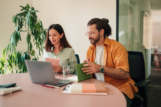 Diverse business professionals collaborating on a project during an office meeting, brainstorming ideas for success and growth