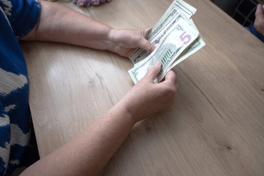 A woman is counting money&mdash;US dollars.
