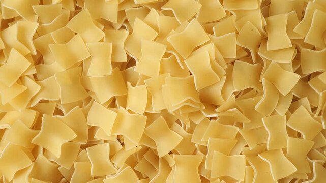 Uncooked italian quadretti pasta rotating background