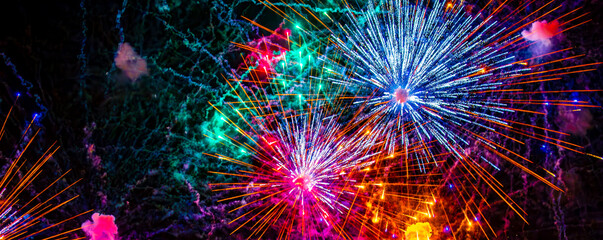 Fototapeta premium Fireworks close-up. Multicolored fireworks in the night sky, bright festive background with space for text.