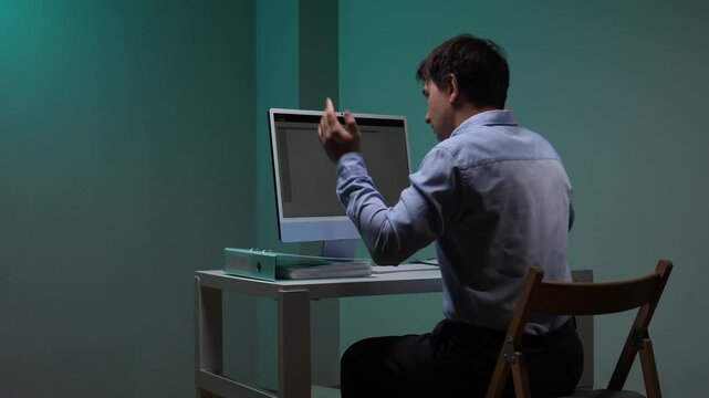 Frustrated office worker throws up his hands at a cluttered desk, staring at a computer in despair from burnout, deadline pressure, technical problems and mounting stress