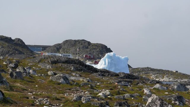 Large Iceberg Rising Between Houses in Nuuk Greenland