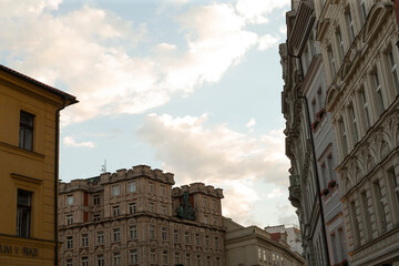 Ornate historic building facades with decorative windows and cornices against soft cloudy sky, warm late afternoon light © Alena