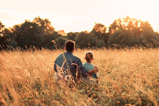 Father and Son Sitting Together at Sunset Concept of Love, Guidance, Support and Fatherhood
