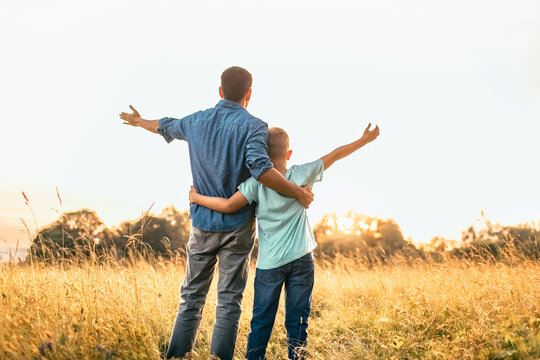 Father and Son Embracing with Open Arms at Sunset Concept of Faith, Love, Freedom and Hope
