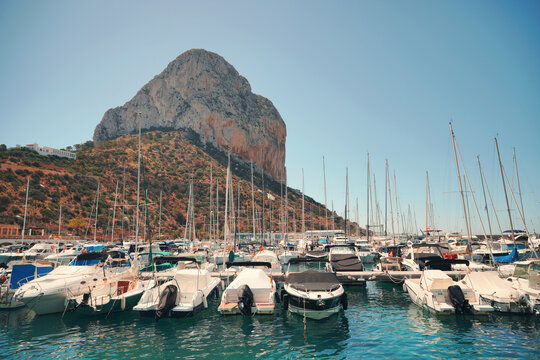 Scenic view of Calpe marina port filled with yachts and famous Pe&ntilde;on de Ifach cliff background