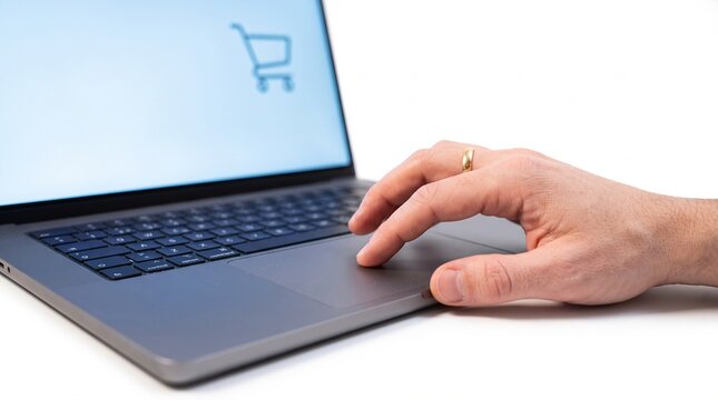 Hand using laptop trackpad for online shopping with shopping cart icon