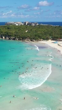 Caribbean beach Macao with azure water and stone cliff. Dominican Republic. Aerial drone view. Vertical footage
