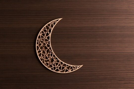 Intricate, laser-cut crescent moon overlay on rich, dark wood grain