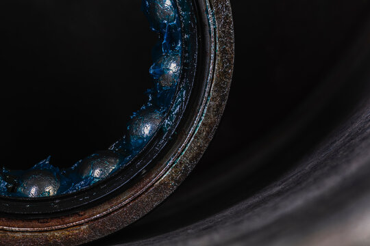 Old industrial ball bearing with grease, raceways and rolling elements, mechanical component, support loads and reduce friction