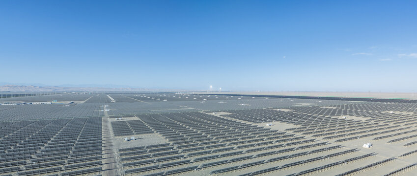 Aerial View of Vast Solar Photovoltaic Power Station in Dunhuang Gobi Desert with Glowing Molten Salt Solar Thermal Towers