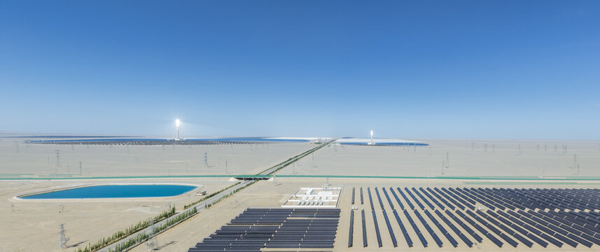 Aerial View of Dunhuang Photoelectric Industrial Park with Solar Photovoltaic Farm, Molten Salt Thermal Towers and Reservoir in Gobi Desert