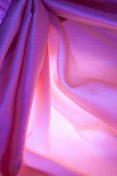  Textura de fondo de tela de seda rosa iluminada. Fondo de tela suave con pliegues brillantes; transmite elegancia, feminidad, lujo y delicadeza.