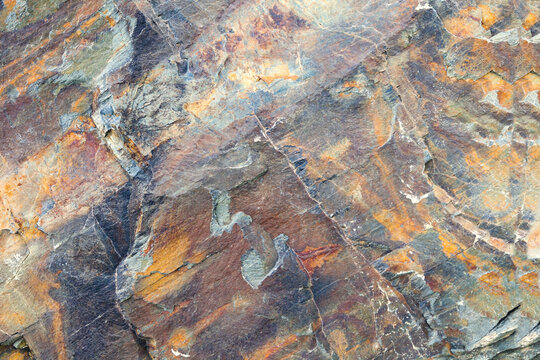  Textura de roca mineral de color desgastada. Superficie geol&oacute;gica rugosa con minerales multicolores; transmite resistencia natural, antig&uuml;edad y texturas terrosas.