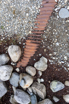 Rusted Corrugated Metal Among Gravel and Rocks in a Natural Stone Garden, BC Canada