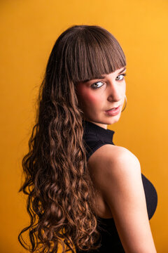 Young woman confidently posing with long curly hair
