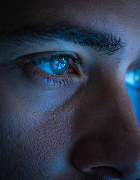 A closeup of a human eye reflecting a digital screen, capturing the focus and intensity of modern technology. This evocative shot highlights themes of screen addiction and digital connection.